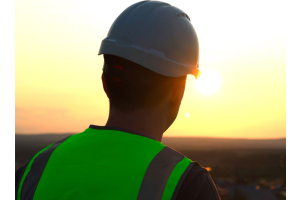 construction worker with hard hat watching the sunset